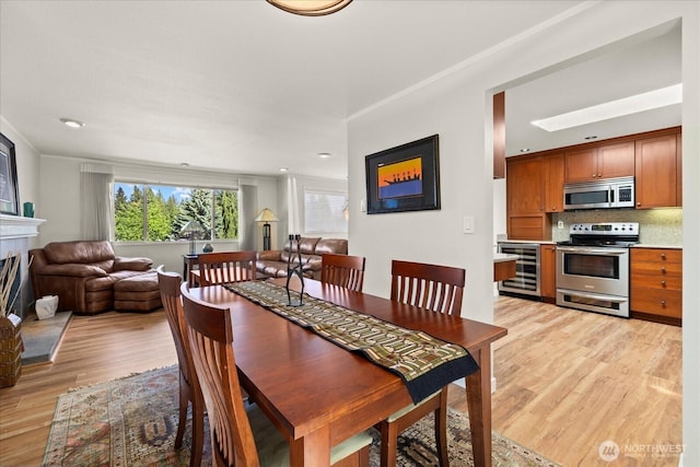 9 199th Pl SE, Bothell, WA 98012 - dining space with wine cooler, light wood-style floors, a fireplace, and recessed lighting