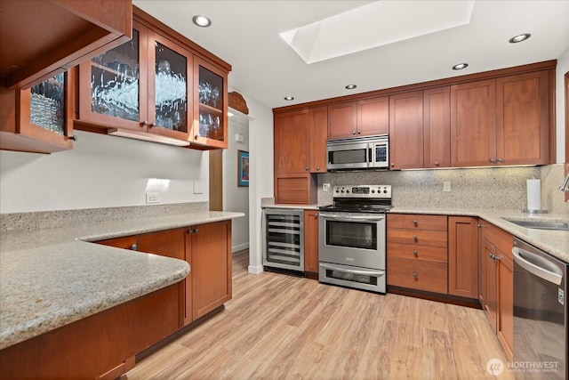 9 199th Pl SE, Bothell, WA 98012 - kitchen featuring appliances with stainless steel finishes, wine cooler, a skylight, light wood-style flooring, and recessed lighting