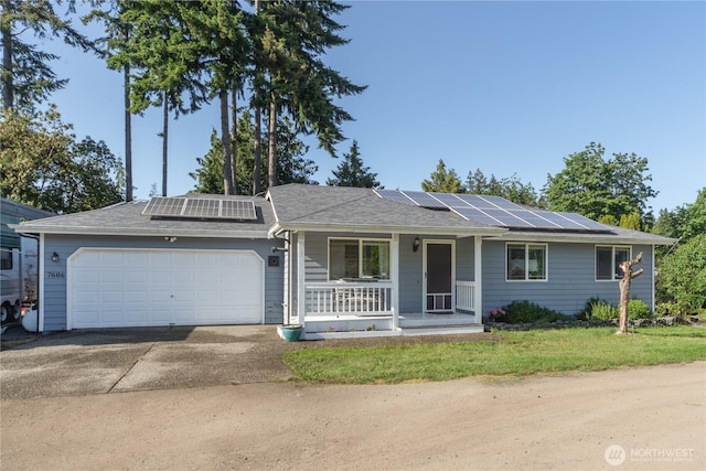 7606 Illahee Rd NE, Bremerton, WA 98311 - ranch-style house with covered porch, solar panels, an attached garage, driveway, and a front lawn