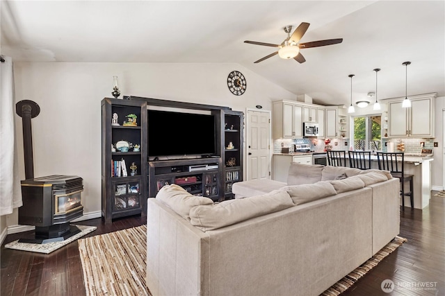 7606 Illahee Rd NE, Bremerton, WA 98311 - living area featuring a ceiling fan, a wood stove, lofted ceiling, dark wood-style floors, and baseboards