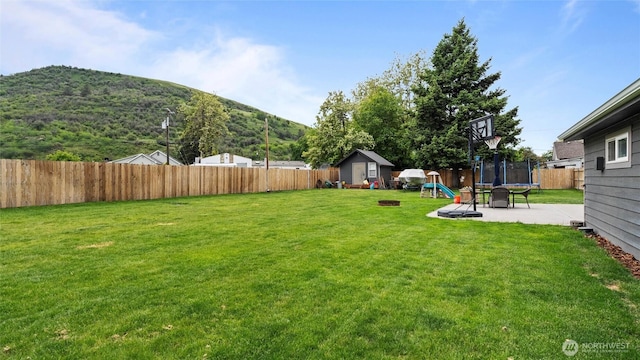 311 W Clay, Dayton, WA 99328 - view of yard featuring a trampoline, a mountain view, a patio area, and an outdoor fire pit
