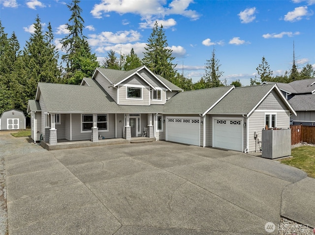 13123 320th Street Ct E, Graham, WA 98338 - view of front of house with a garage, driveway, covered porch, and a shingled roof