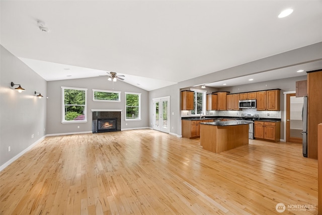 13123 320th Street Ct E, Graham, WA 98338 - kitchen with appliances with stainless steel finishes, open floor plan, a ceiling fan, light wood-type flooring, and a sink