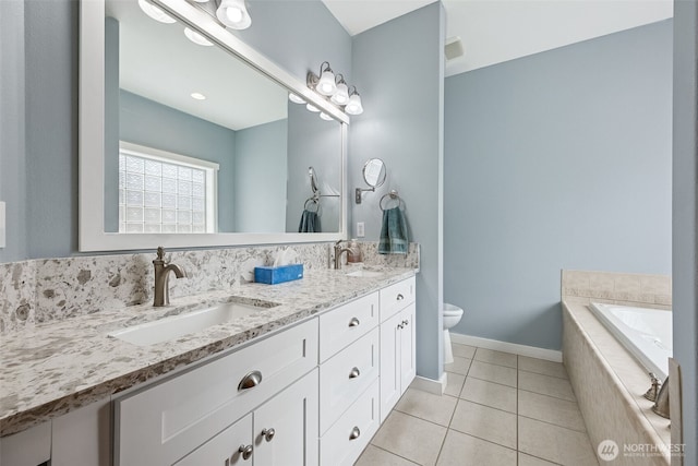 13123 320th Street Ct E, Graham, WA 98338 - bathroom with toilet, double vanity, tile patterned floors, a bath, and baseboards