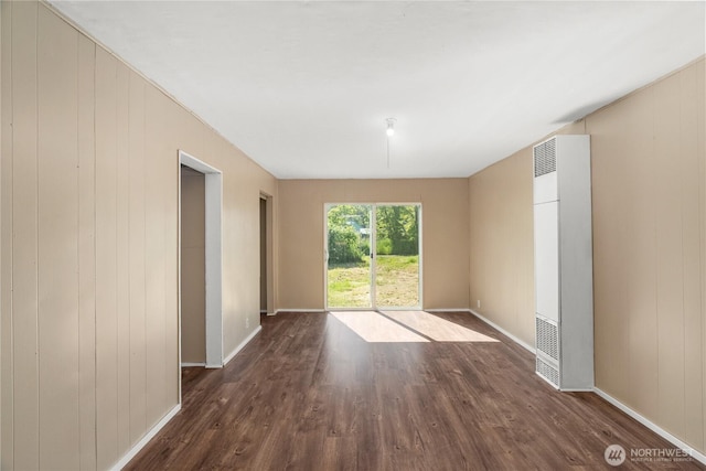 1109 River St, Hoquiam, WA 98550 - spare room featuring a heating unit, wood finished floors, baseboards, and wooden walls