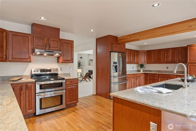2433 18th St SE, Puyallup, WA 98374 - kitchen featuring stainless steel appliances, under cabinet range hood, a sink, light wood-style flooring, and recessed lighting