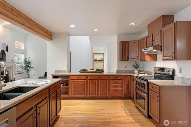 2433 18th St SE, Puyallup, WA 98374 - kitchen featuring appliances with stainless steel finishes, under cabinet range hood, a sink, a peninsula, and light stone countertops