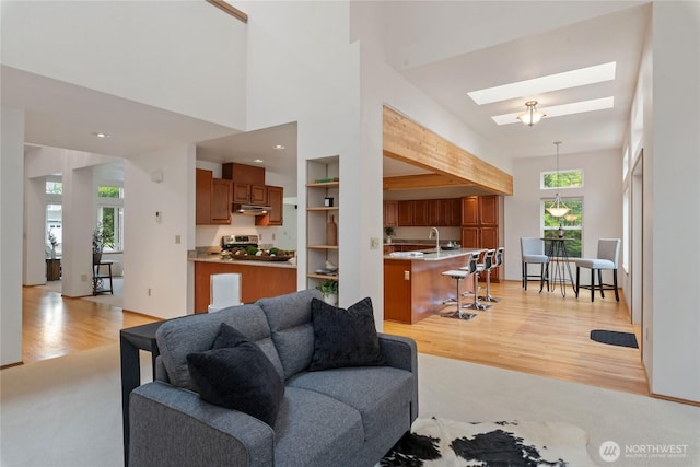 2433 18th St SE, Puyallup, WA 98374 - living room featuring light wood-style floors, a skylight, and a high ceiling