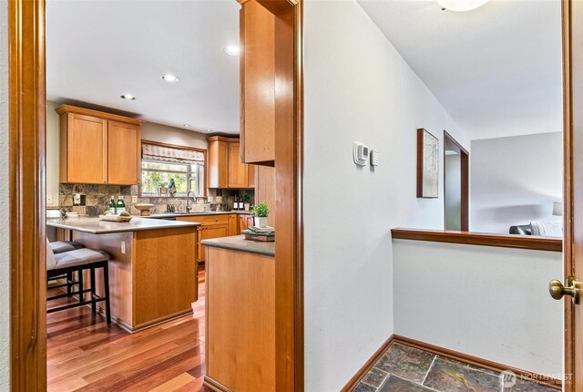 16515 126th Ave NE, Woodinville, WA 98072 - kitchen with a sink, decorative backsplash, baseboards, a kitchen breakfast bar, and a peninsula