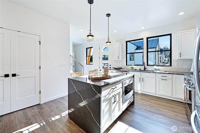 3906 Crosswinds Ct, Anacortes, WA 98221 - kitchen featuring a sink, stainless steel microwave, tasteful backsplash, healthy amount of natural light, and recessed lighting