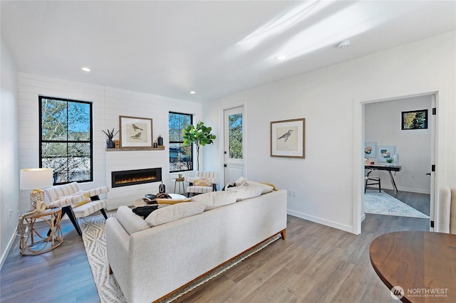 3906 Crosswinds Ct, Anacortes, WA 98221 - living room featuring a glass covered fireplace, baseboards, wood finished floors, and recessed lighting
