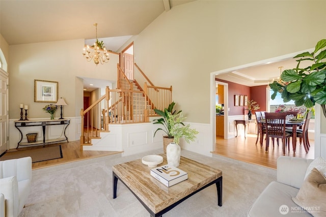 1875 Parkview Dr NE, Tacoma, WA 98422 - living room featuring a chandelier, stairway, wainscoting, high vaulted ceiling, and wood finished floors