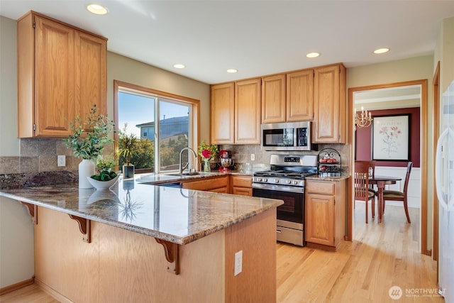 1875 Parkview Dr NE, Tacoma, WA 98422 - kitchen with stainless steel appliances, light stone counters, a peninsula, light wood-style floors, and recessed lighting