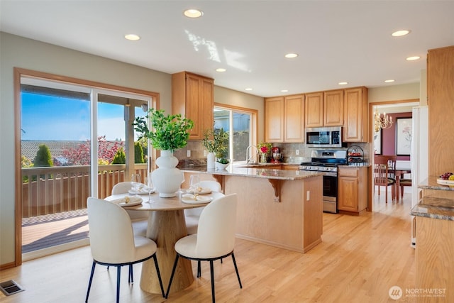 1875 Parkview Dr NE, Tacoma, WA 98422 - kitchen featuring appliances with stainless steel finishes, a sink, light stone counters, decorative backsplash, and a peninsula