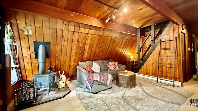 148 Seagate St SW, Ocean Shores, WA 98569 - sitting room with wooden walls, stairs, a wood stove, wooden ceiling, and carpet floors