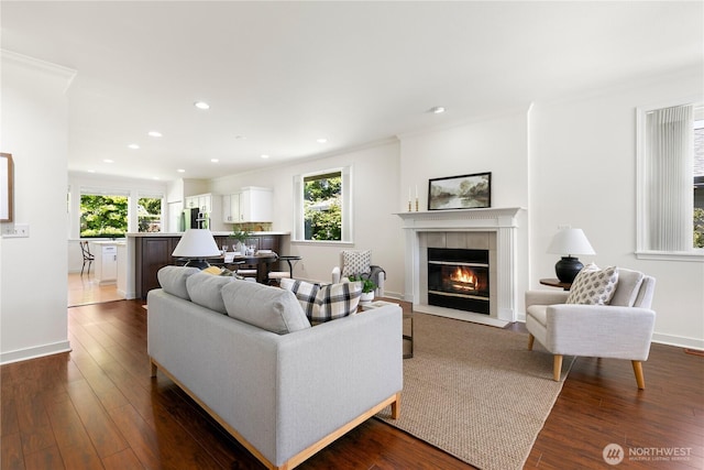 7417 53rd Street Ct W, University Place, WA 98467 - living room with dark wood-style floors, a tiled fireplace, recessed lighting, crown molding, and baseboards