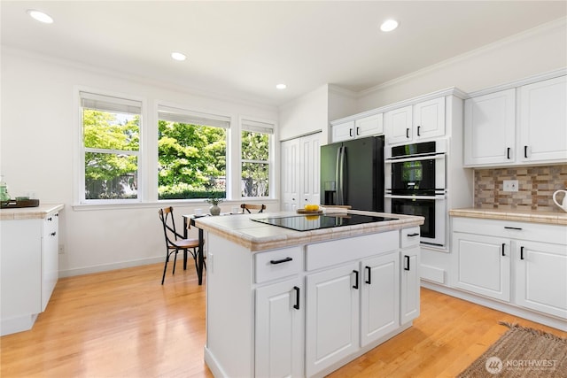 7417 53rd Street Ct W, University Place, WA 98467 - kitchen featuring black appliances, a kitchen island, tasteful backsplash, light wood finished floors, and ornamental molding