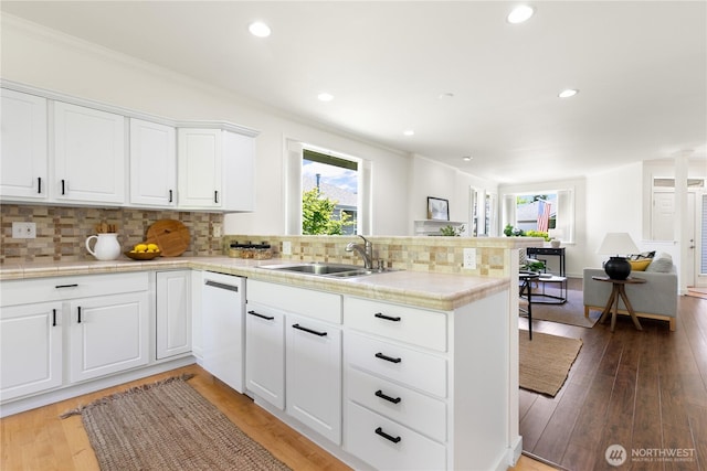 7417 53rd Street Ct W, University Place, WA 98467 - kitchen featuring a sink, a peninsula, dishwasher, tasteful backsplash, and white cabinetry