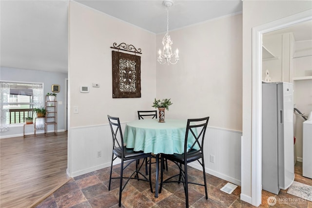 300 SW 7th Ave Unit 127, Battle Ground, WA 98604 - dining space with a chandelier, wainscoting, washer / clothes dryer, ornamental molding, and dark wood-style flooring