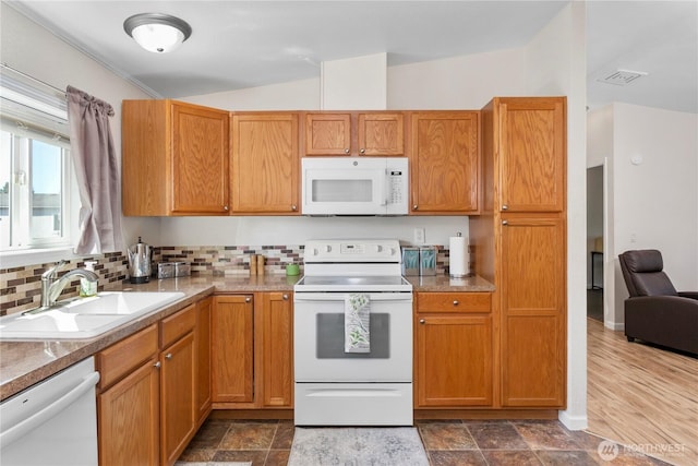 300 SW 7th Ave Unit 127, Battle Ground, WA 98604 - kitchen with white appliances, lofted ceiling, decorative backsplash, and brown cabinets