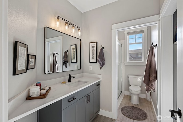 656 Daley St Unit 102, Edmonds, WA 98020 - bathroom featuring toilet, vanity, a shower stall, and baseboards
