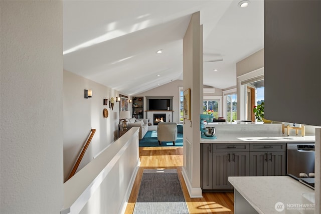 656 Daley St Unit 102, Edmonds, WA 98020 - hallway with light wood-style flooring, vaulted ceiling, and an upstairs landing