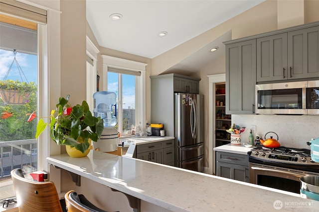 656 Daley St Unit 102, Edmonds, WA 98020 - kitchen with appliances with stainless steel finishes, gray cabinets, light stone counters, recessed lighting, and backsplash