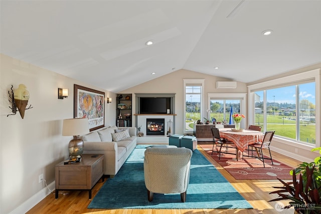 656 Daley St Unit 102, Edmonds, WA 98020 - living room featuring lofted ceiling, healthy amount of natural light, baseboards, light wood-type flooring, and a glass covered fireplace