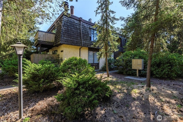 8627 25th Ave SW Unit B, Seattle, WA 98106 - rear view of property featuring mansard roof, stucco siding, and a chimney