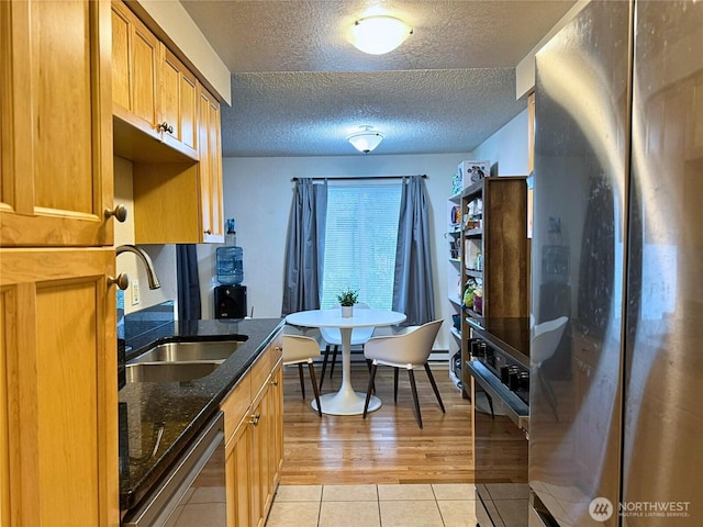 8627 25th Ave SW Unit B, Seattle, WA 98106 - kitchen with freestanding refrigerator, dishwasher, a sink, oven, and a textured ceiling