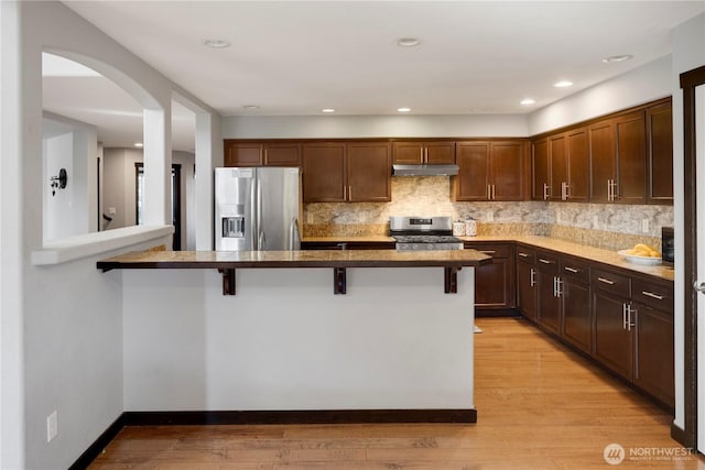 1875 Mckinley St, Ferndale, WA 98248 - kitchen featuring stainless steel appliances, under cabinet range hood, a kitchen bar, backsplash, and recessed lighting