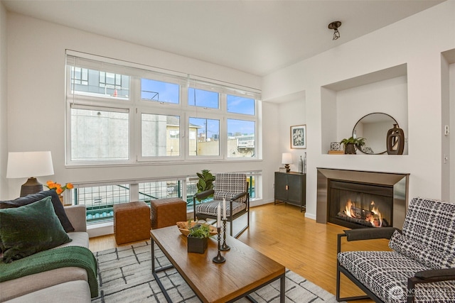 17 W Mercer St Unit 218, Seattle, WA 98119 - living room featuring plenty of natural light, light wood-type flooring, a warm lit fireplace, and baseboards