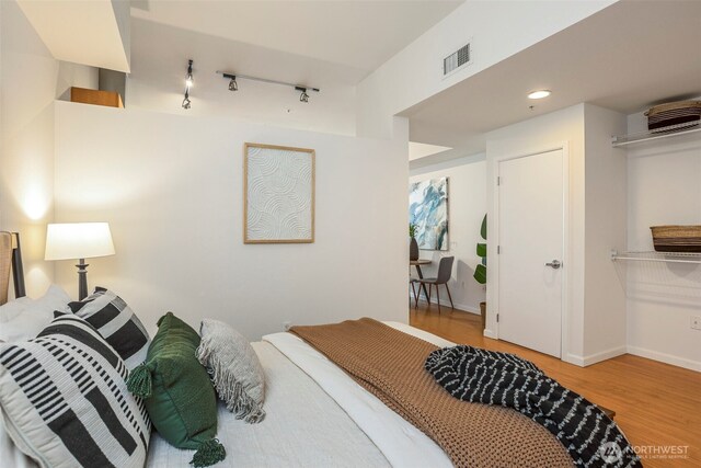 17 W Mercer St Unit 218, Seattle, WA 98119 - bedroom featuring wood finished floors, track lighting, and baseboards