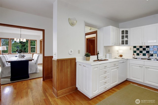 2433 E Valley St, Seattle, WA 98112 - kitchen featuring a sink, white dishwasher, a wainscoted wall, glass insert cabinets, and light wood-style flooring