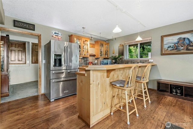 13911 Meridian Ave N, Marysville, WA 98271 - kitchen featuring stainless steel fridge with ice dispenser, rail lighting, glass insert cabinets, wood finished floors, and decorative backsplash