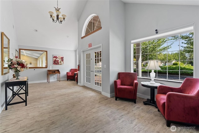 3516 Meadowbrook Ln SE, Lacey, WA 98503 - sitting room featuring wood finished floors, high vaulted ceiling, a chandelier, and baseboards