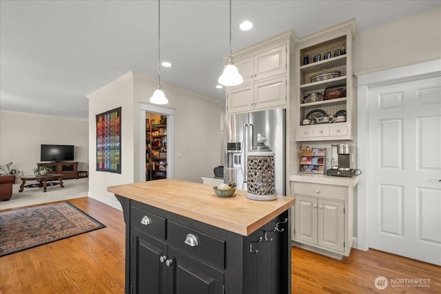 1259 Insel Rd, Woodland, WA 98674 - kitchen featuring dark cabinets, stainless steel refrigerator with ice dispenser, butcher block countertops, ornamental molding, and light wood-type flooring