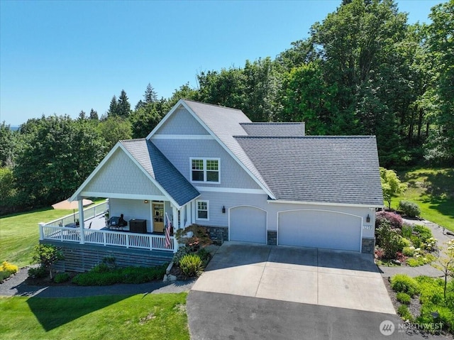 1259 Insel Rd, Woodland, WA 98674 - view of front of home with driveway, stone siding, a front lawn, and a garage