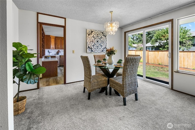 14210 NE 63rd Ct, Redmond, WA 98052 - dining space featuring light carpet, a chandelier, a textured ceiling, and baseboards