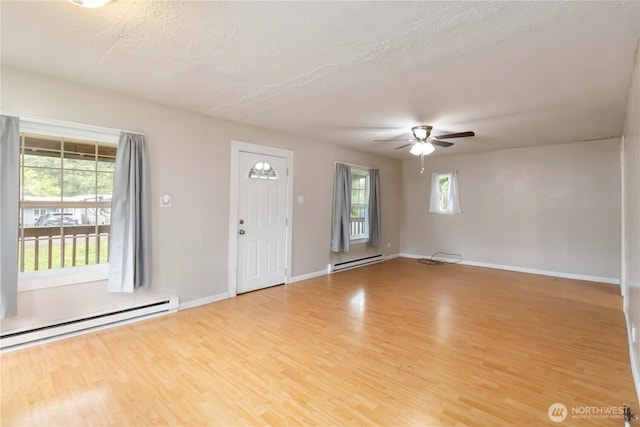 611 NE Pioneer, Castle Rock, WA 98611 - foyer featuring a baseboard heating unit, a ceiling fan, light wood-type flooring, a textured ceiling, and baseboards