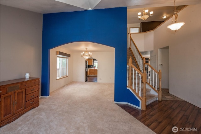 19011 89th Ave E, Puyallup, WA 98375 - spare room featuring a chandelier, arched walkways, stairs, wood finished floors, and a towering ceiling
