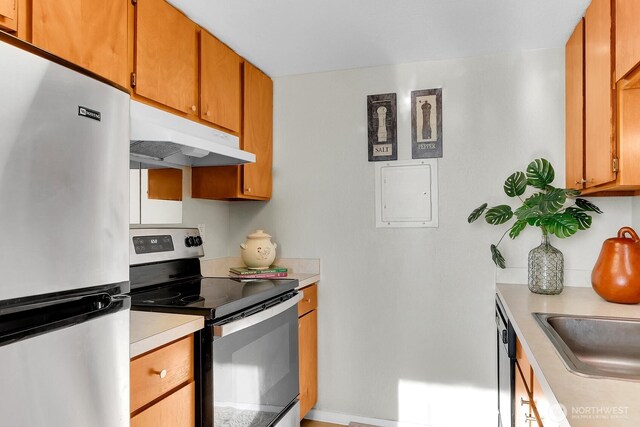 14513 127th Ln NE Unit N46, Kirkland, WA 98034 - kitchen featuring stainless steel appliances, under cabinet range hood, light countertops, brown cabinetry, and baseboards