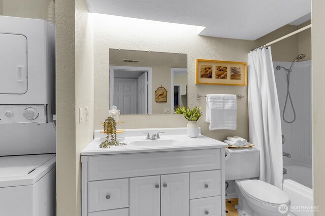 14513 127th Ln NE Unit N46, Kirkland, WA 98034 - bathroom with stacked washing machine and dryer, toilet, vanity, shower / tub combo, and a textured wall