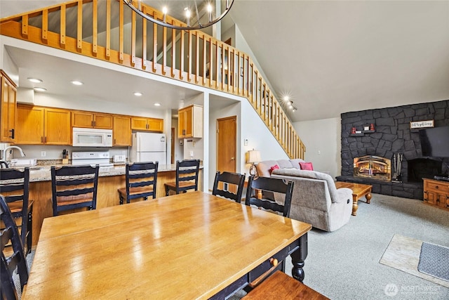1051 Yellowstone, Snoqualmie Pass, WA 98068 - dining area featuring stairway, recessed lighting, a stone fireplace, carpet, and vaulted ceiling