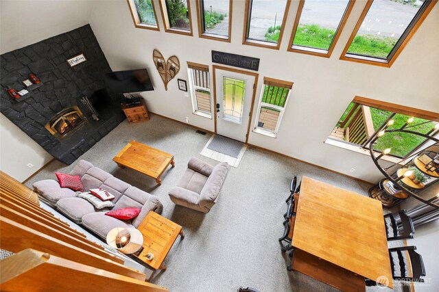 1051 Yellowstone, Snoqualmie Pass, WA 98068 - living room with a high ceiling, a warm lit fireplace, and baseboards