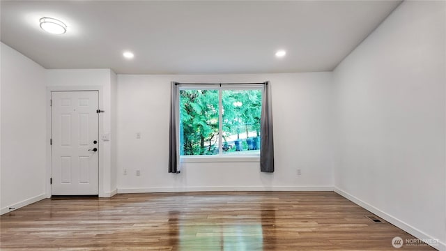 22470 Sunridge Way NE, Poulsbo, WA 98370 - unfurnished room with wood finished floors, baseboards, and recessed lighting