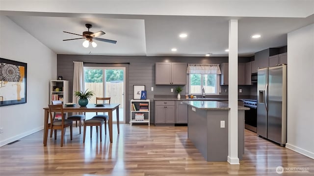 22470 Sunridge Way NE, Poulsbo, WA 98370 - kitchen with stainless steel appliances, gray cabinets, ceiling fan, a center island, and light wood-style flooring