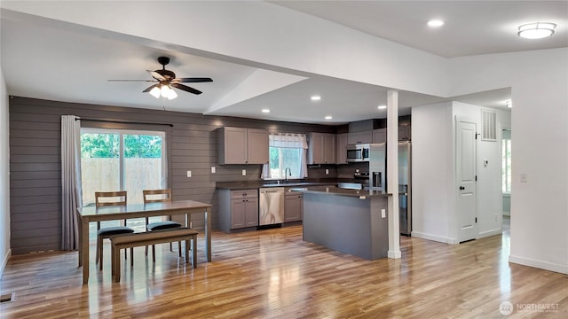 22470 Sunridge Way NE, Poulsbo, WA 98370 - kitchen with stainless steel appliances, dark countertops, a ceiling fan, light wood-style flooring, and baseboards