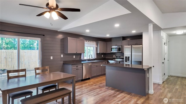 22470 Sunridge Way NE, Poulsbo, WA 98370 - kitchen featuring stainless steel appliances, a sink, dark countertops, light wood finished floors, and vaulted ceiling