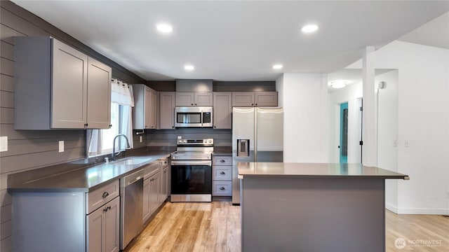 22470 Sunridge Way NE, Poulsbo, WA 98370 - kitchen with stainless steel appliances, a sink, light wood-style flooring, dark countertops, and gray cabinets